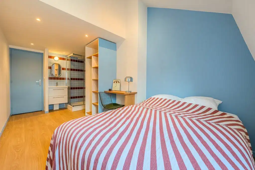 Chambre au mur bleu avec salle de bain privative, coliving Lille Vauban