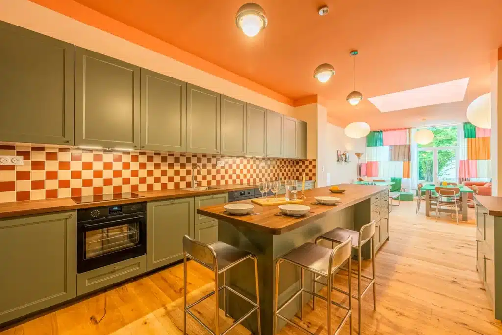Cuisine ouverte avec îlot et tabourets, coliving Maison Bourgogne Lille
