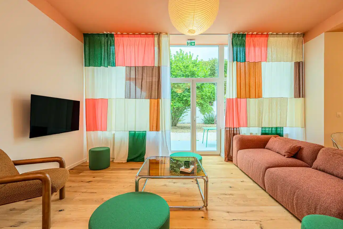 Salon avec baie vitrée donnant sur le jardin, coliving Lille Vauban