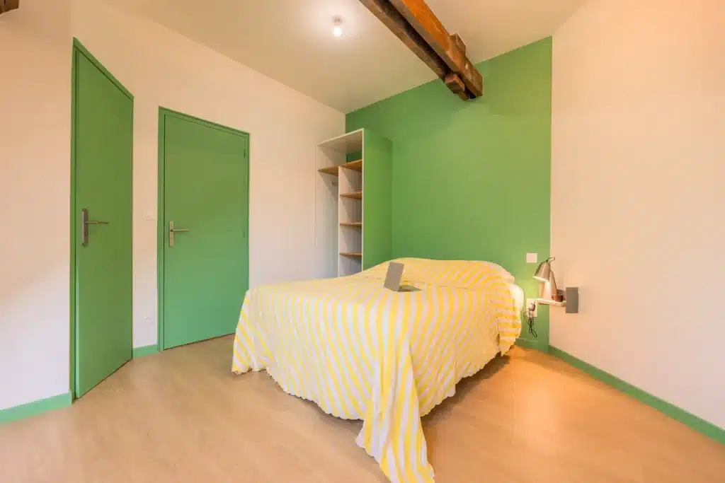 Chambre comfort aux murs verts, coliving Maison République Lille