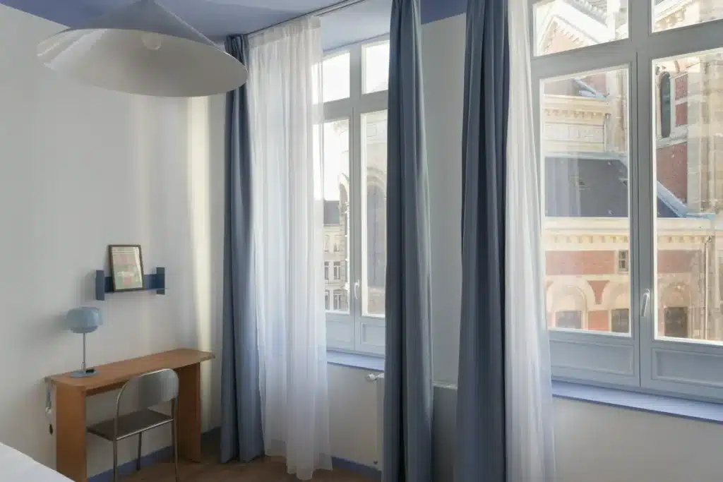 Chambre lumineuse avec grandes fenêtres et bureau, coliving Lille Saint-Michel